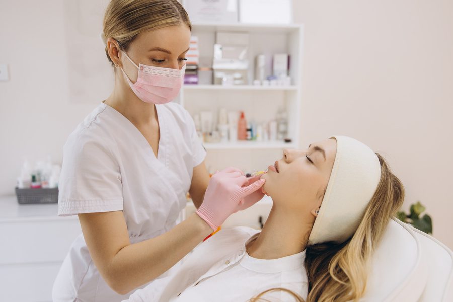Cosmetic professional injecting botox into patient's lips with precision under aesthetic treatment for enhanced appearance