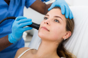 Female receiving face skin lifting procedure in aesthetic cosmetology clinic